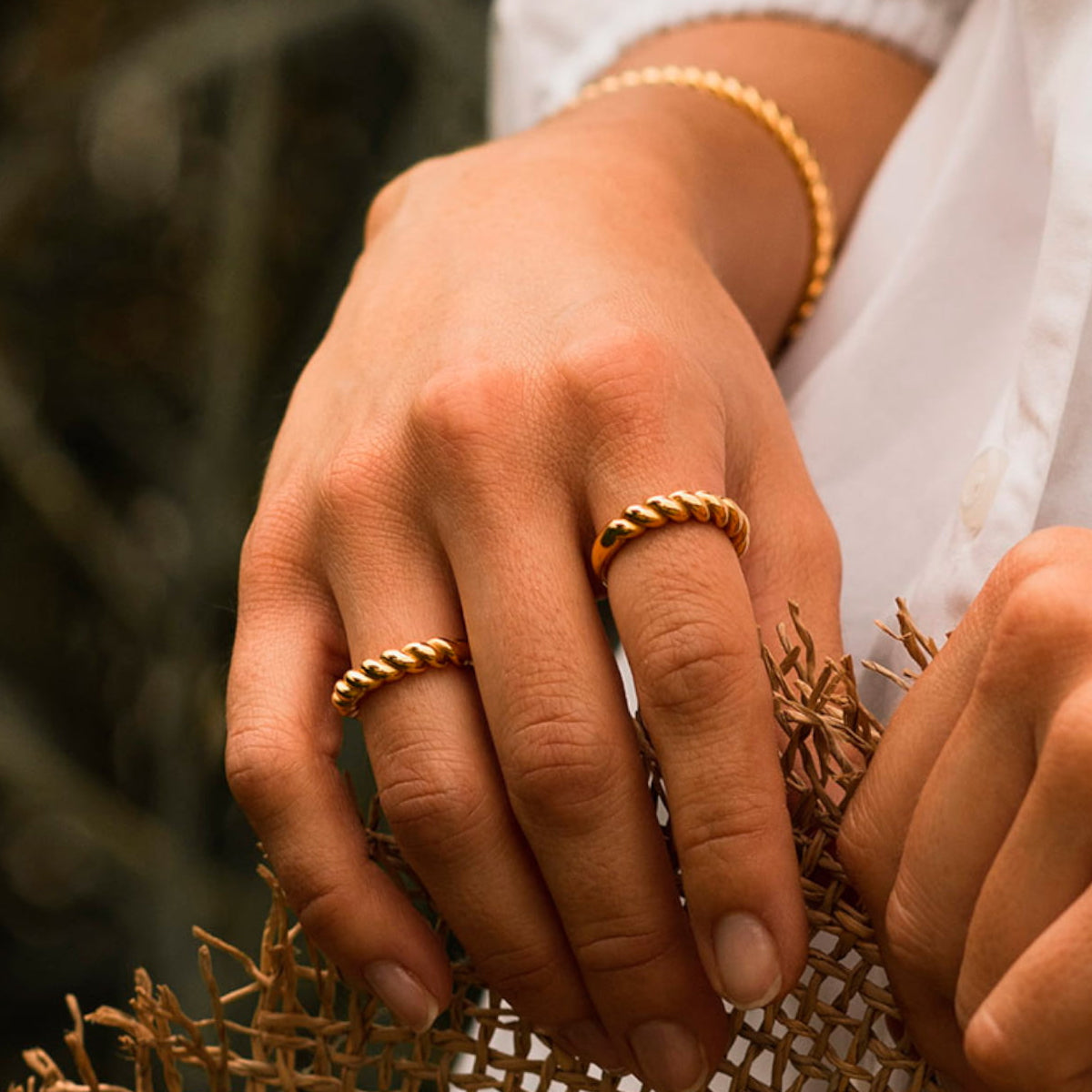 AN JEWELS JEWELRY Mod. AAC.R05Y-9 featuring elegant gold rings and bracelet on woman's hand.