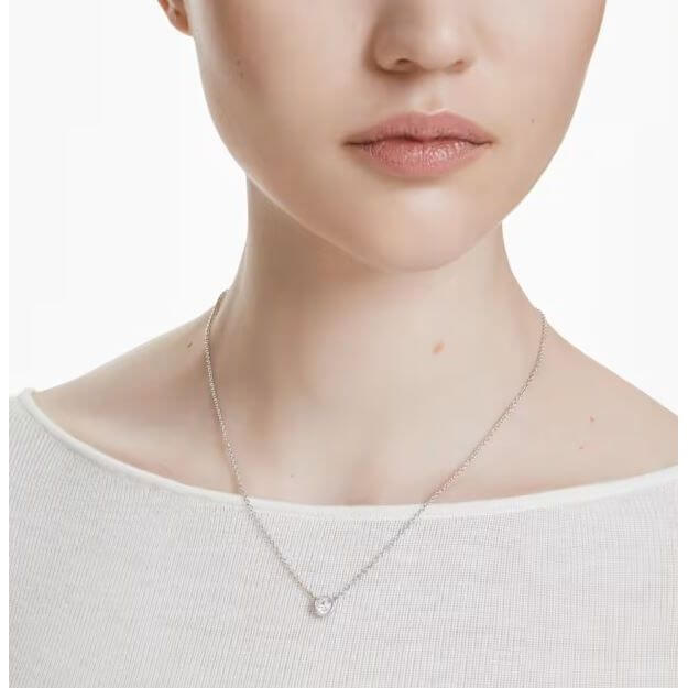 Close-up of woman wearing SWAROVSKI Mod. 5696039 minimalist pendant necklace from Imber Collection, rhodium plated, round-cut stone.