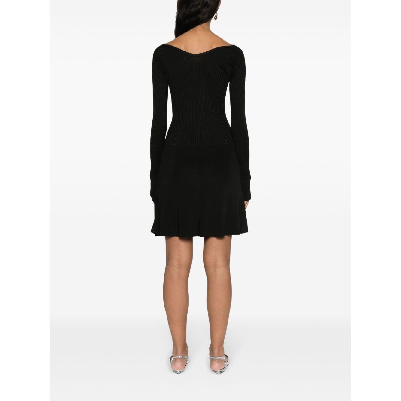 Model wearing JACQUEMUS Dresses Black ribbed knit dress with wide neck, long sleeves, and flared skirt, view from the back.