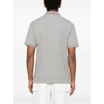 Back view of a Thom Browne T-shirts and Polos Light Grey Rwb cotton polo shirt with button placket and polo collar, worn by a model.