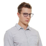 Man wearing Police Blue Men Glasses Frame, blue full-rim trapezium style with demo lenses, made from metal and plastic.