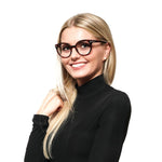Woman wearing Swarovski Brown Women Glasses Frame with full-rim plastic design and spring hinge, holding a pose in a black sweater.