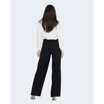 Woman wearing Jacqueline De Yong Black Polyester Pant in elegant palazzo style, seen from the back, paired with a white blouse.