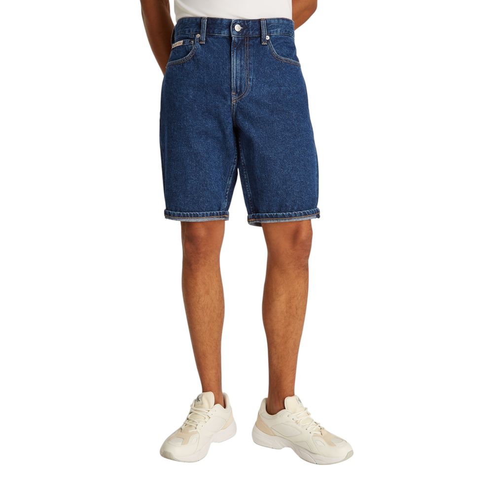 Model wearing Calvin Klein Jeans Blue Cotton Bermuda Shorts with white sneakers, casual summer fashion.