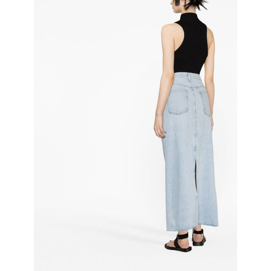 Back view of model wearing AGOLDE PRE Skirts Clear Blue, a light blue denim maxi skirt with frayed edges and rear vent.
