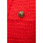 Close-up of Balmain Red Nylon Suits & Blazer showcasing gold button on wool-viscose blend with raw-cut detail.