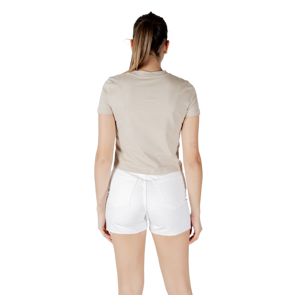 Back view of woman wearing Calvin Klein Jeans Beige Recycled Cotton T-Shirt and white shorts, showcasing minimalist design with logo.