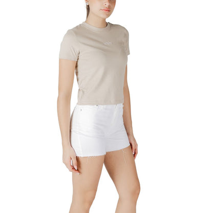 Woman wearing Calvin Klein Jeans Beige Recycled Cotton T-Shirt with white shorts, showcasing a minimalist design and Calvin Klein logo.