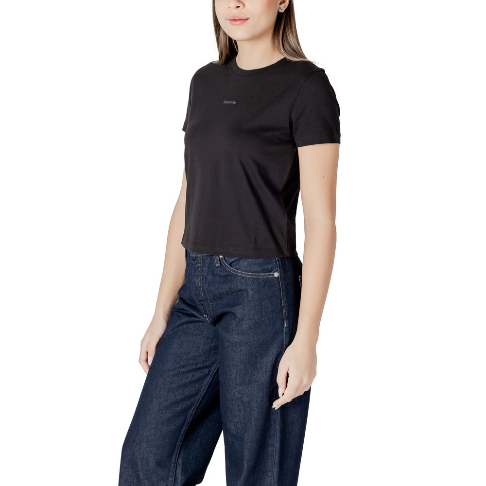 Woman wearing Calvin Klein Jeans Black Recycled Cotton Sportswear t-shirt with minimalist design and logo, paired with jeans.