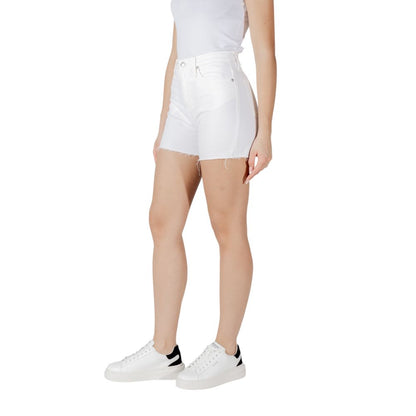Side view of model wearing Calvin Klein Jeans White Cotton Shorts with sneakers, showcasing the casual summer style and sustainable fabric.