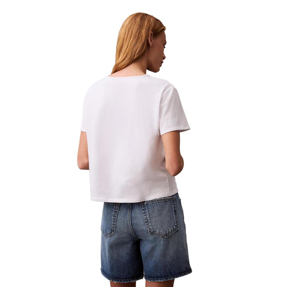 Back view of woman wearing Calvin Klein Jeans White Recycled Cotton T-Shirt and denim shorts.