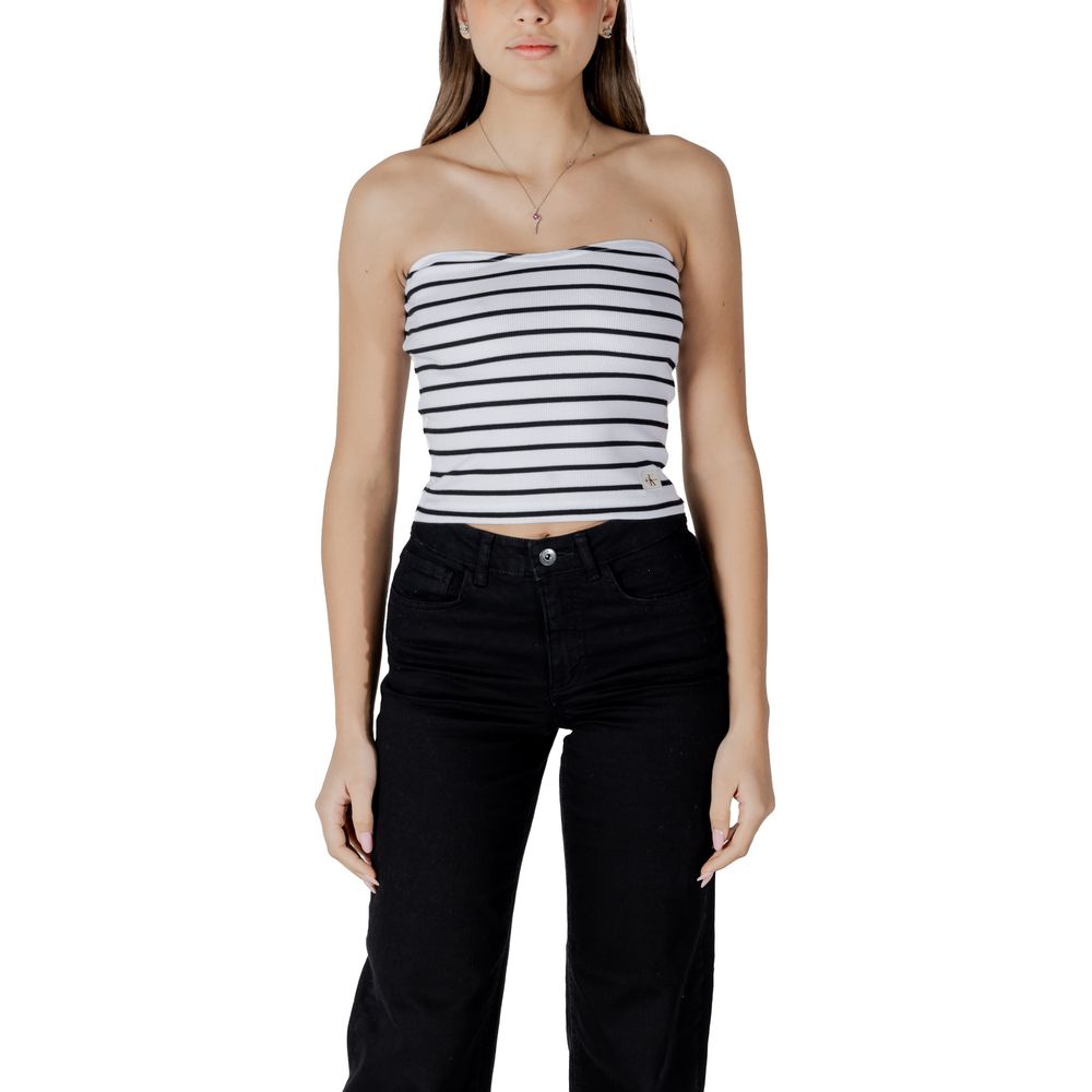 Woman wearing a strapless black and white striped top with black jeans, styling a casual look for everyday wear.