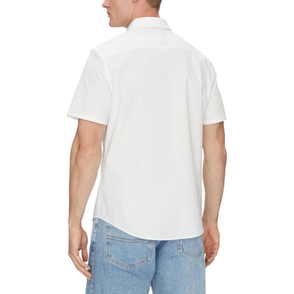 Back view of a man wearing a Calvin Klein White Organic Cotton Shortsleeve Shirt, paired with blue jeans.