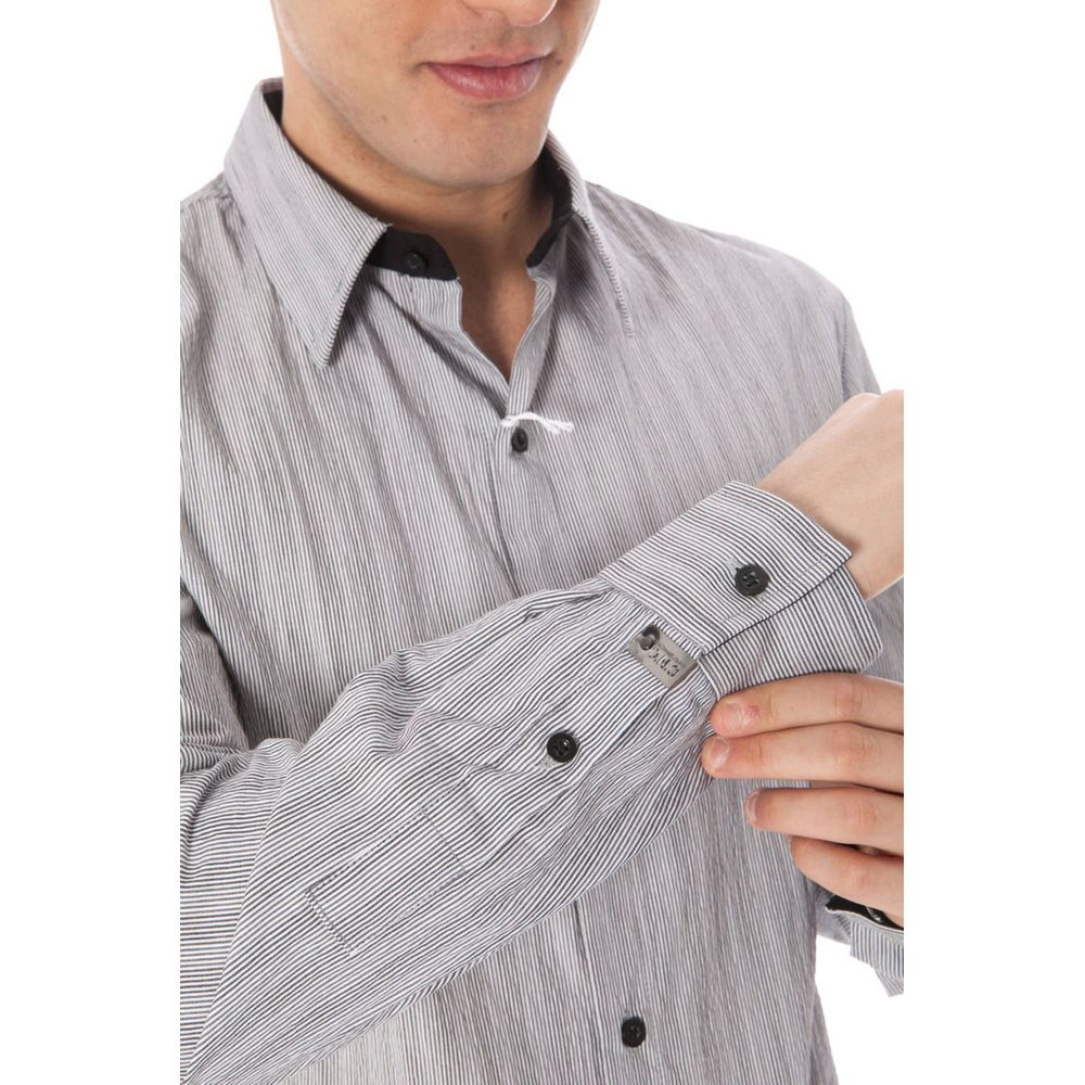 Man adjusting sleeve of Costume National White Cotton Men Shirt with elegant collar and button cuffs, showcasing minimalist Italian design.