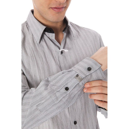 Man adjusting sleeve of Costume National White Cotton Men Shirt with elegant collar and button cuffs, showcasing minimalist Italian design.