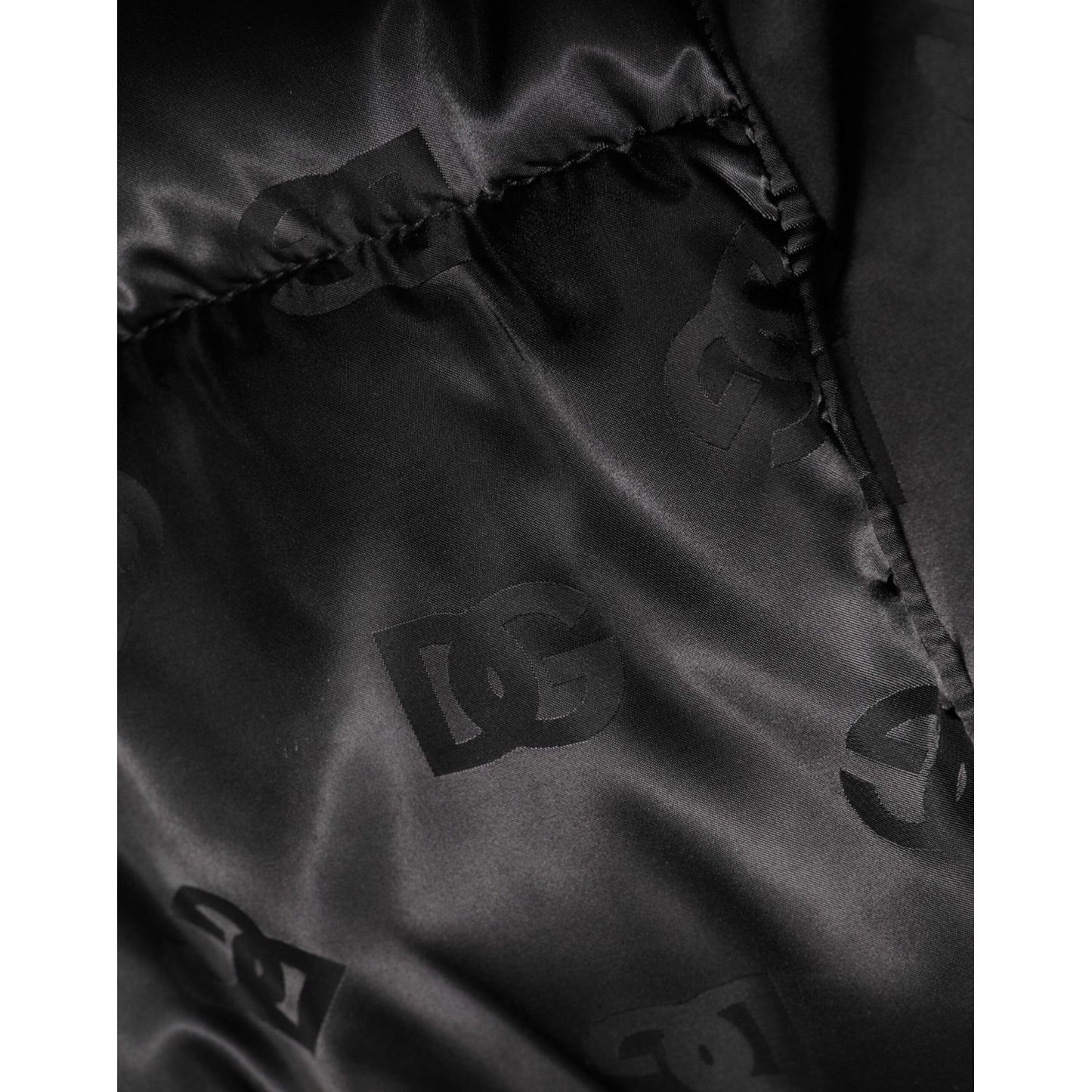 Close-up of Dolce & Gabbana Black Monogram Logo Puffer Nylon Hooded Jacket's DG design, highlighting the detailed monogram pattern.