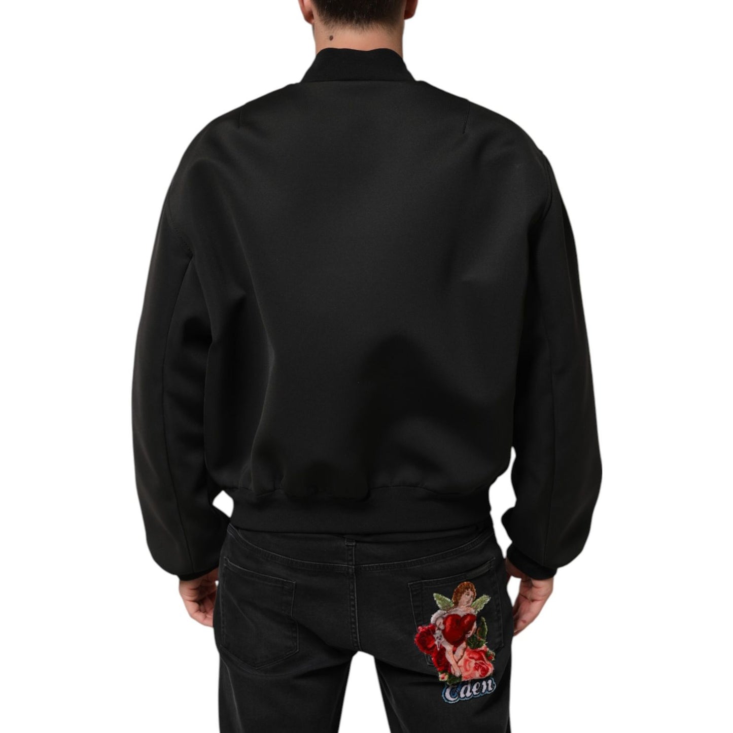 Rear view of Dolce & Gabbana Black Polyester Logo Plaque Bomber Jacket worn by a man showcasing back detail.