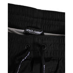 Close-up of Dolce & Gabbana Black White Striped DG Logo Men Short Swimwear with drawstring and elastic waistband.