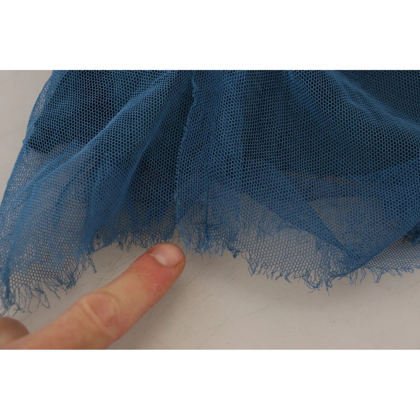 Close-up of defect on Dolce & Gabbana Blue Mesh Trim Ruched Tulle Sheath Dress showing holes and pulled threads.