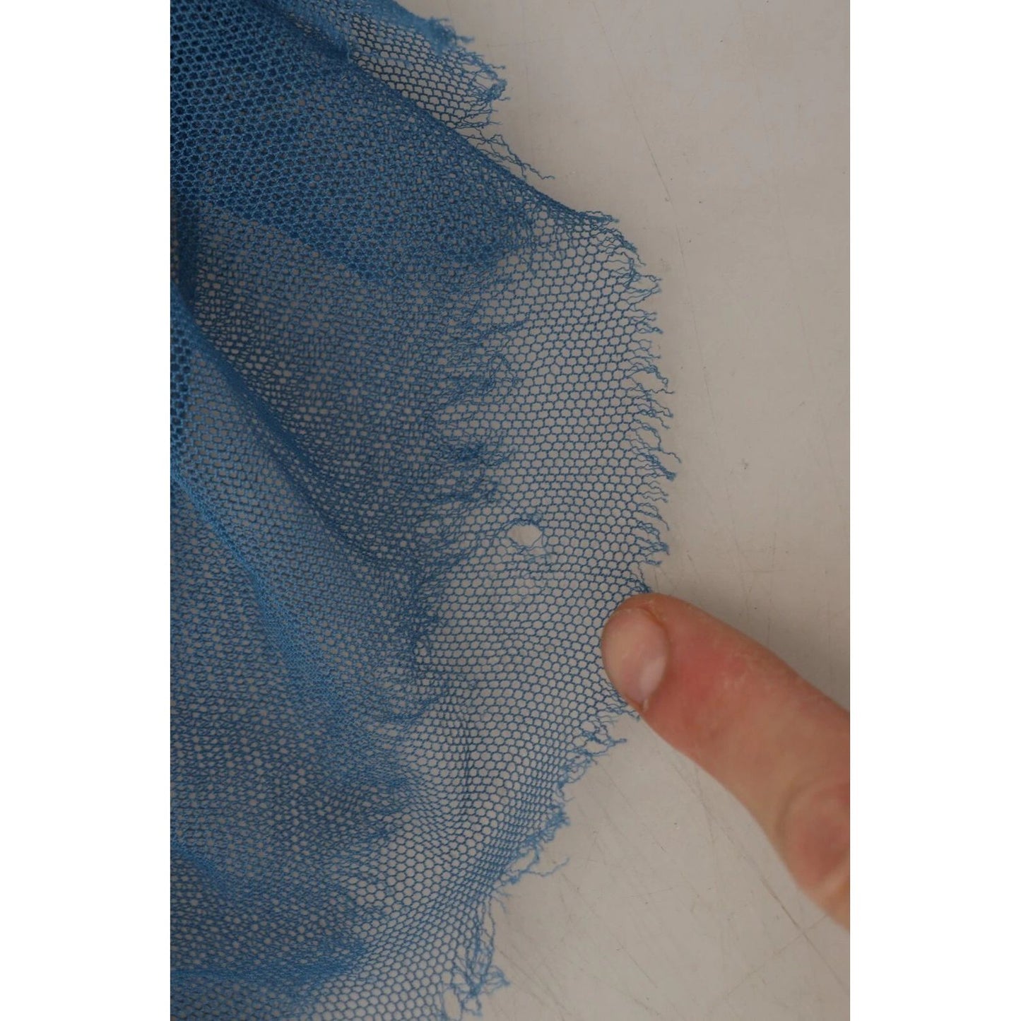 Close-up of a minor defect in Dolce & Gabbana Blue Mesh Trim Ruched Tulle Sheath Dress, showing a hole and pulled threads.