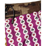Dolce & Gabbana Multicolor Playing Card Camouflage Shorts Swimwear with heart and club motif, magenta and mustard hues, camouflage accents.