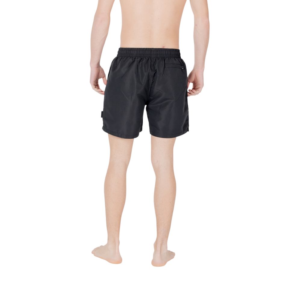 Back view of EA7 Emporio Armani Black Polyester Swim Shorts on a male model, showcasing the stylish design and comfortable fit.