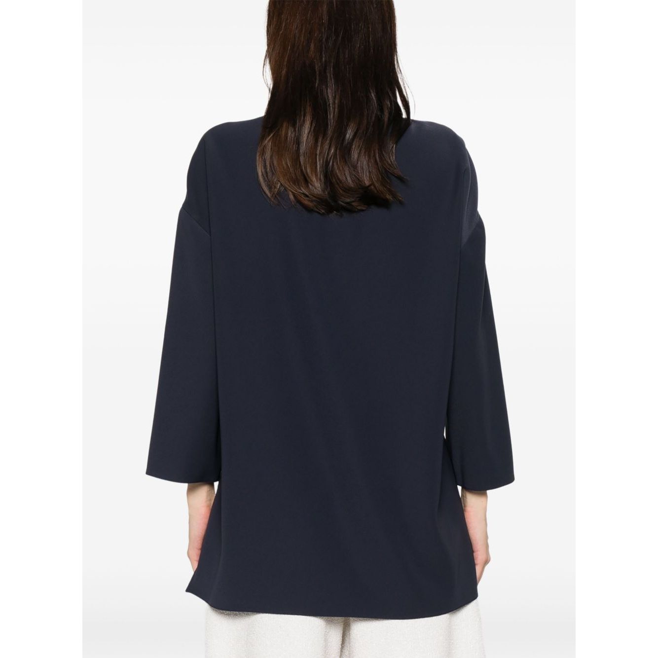 Back view of Emporio Armani cady blouse in oxford blue with drop shoulders and side slits, shown on model.