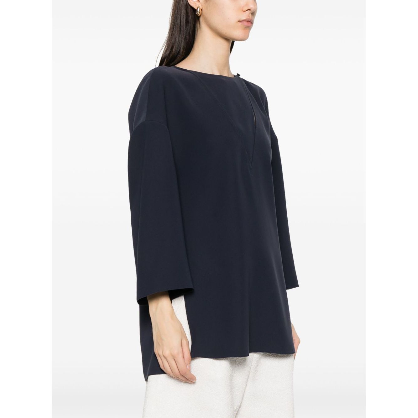 Woman wearing Emporio Armani cady blouse in oxford blue with drop shoulders, side slits, and front button fastening.