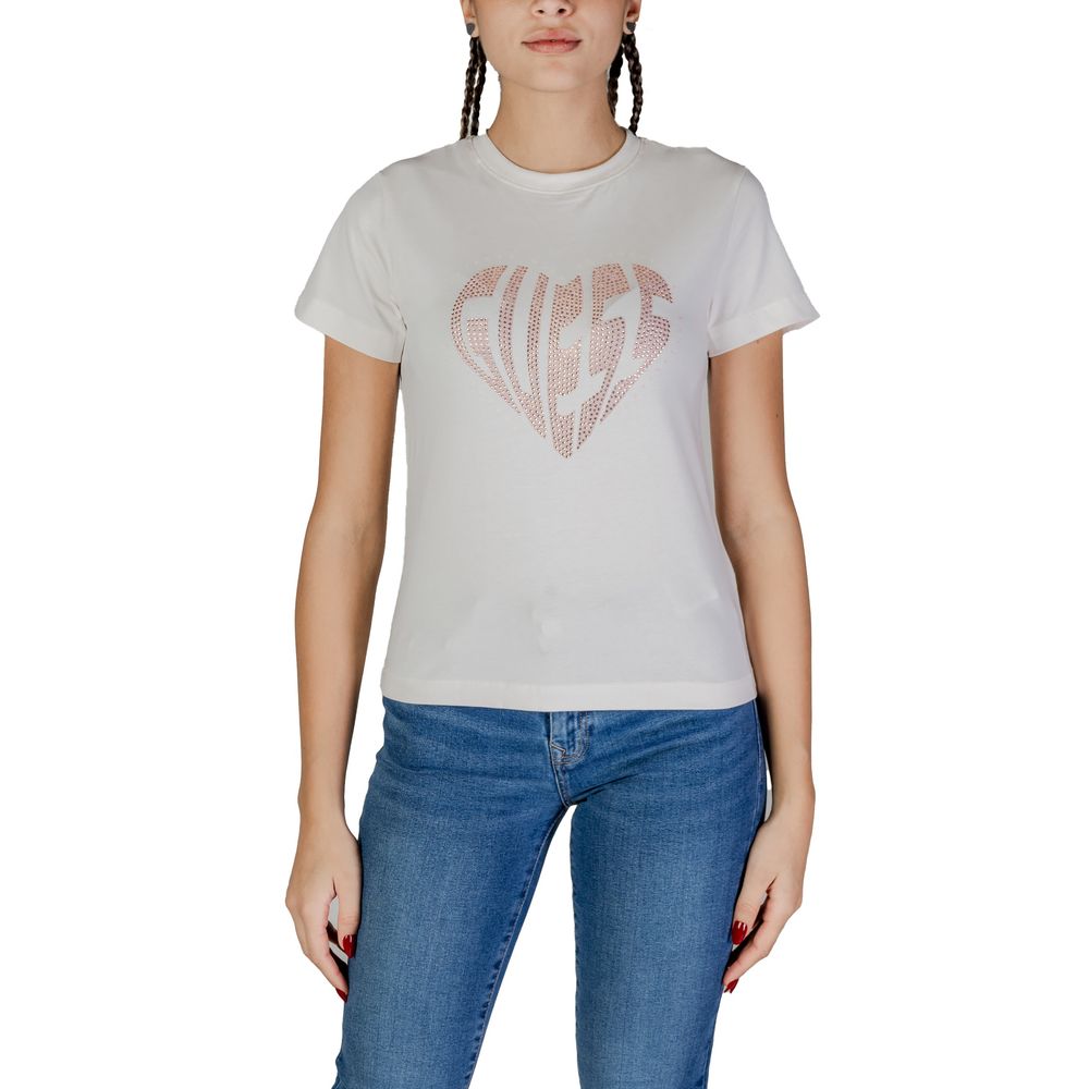 Woman wearing Guess Active Cream Cotton T-Shirt with rhinestone-adorned Guess logo, paired with jeans for a casual look.