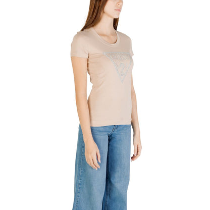 Woman wearing Guess Beige Cotton T-Shirt with shiny triangle logo, slim fit short-sleeved design, styled with classic denim jeans.