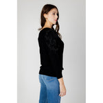 Woman wearing Guess Black Viscose Sportswear featuring long-sleeve top with Guess logo and sparkling details, enhancing feminine silhouette.