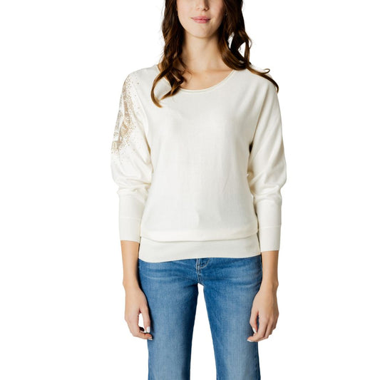 Woman wearing Guess White Viscose Sportswear sweater with batwing sleeves, featuring a subtle logo detail, paired with blue jeans.