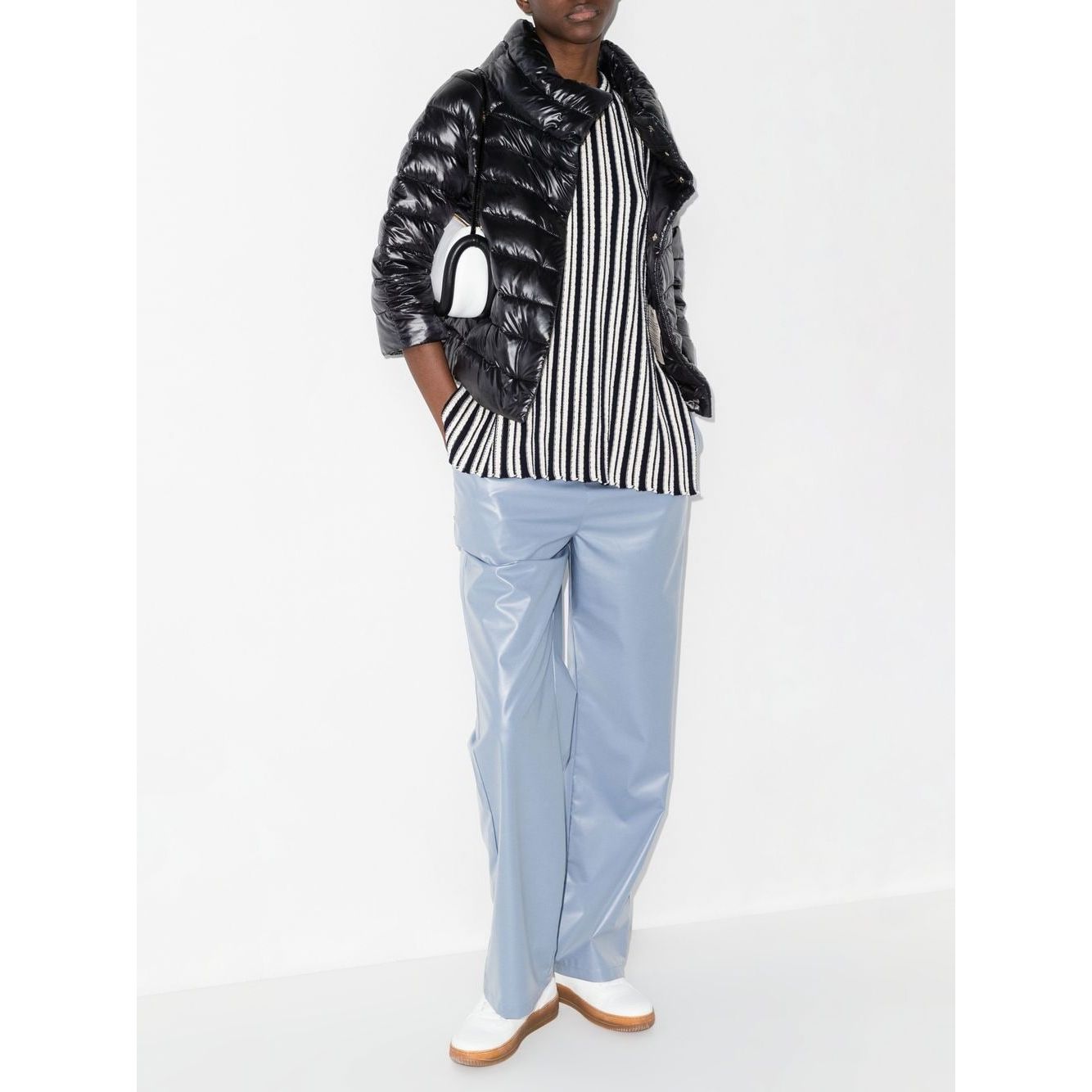 Model wearing Herno Jackets Black, Sofia nylon cape, paired with a striped shirt and blue pants.