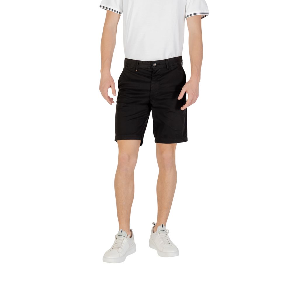 Model wearing Hugo Boss Black Cotton Bermuda Shorts with white sneakers and shirt, showcasing slim fit design for a modern casual look.
