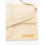Jacquemus Le Grand Bambino Beige Bag with gold logo, leather material, adjustable strap, and magnetic flap closure close-up image.