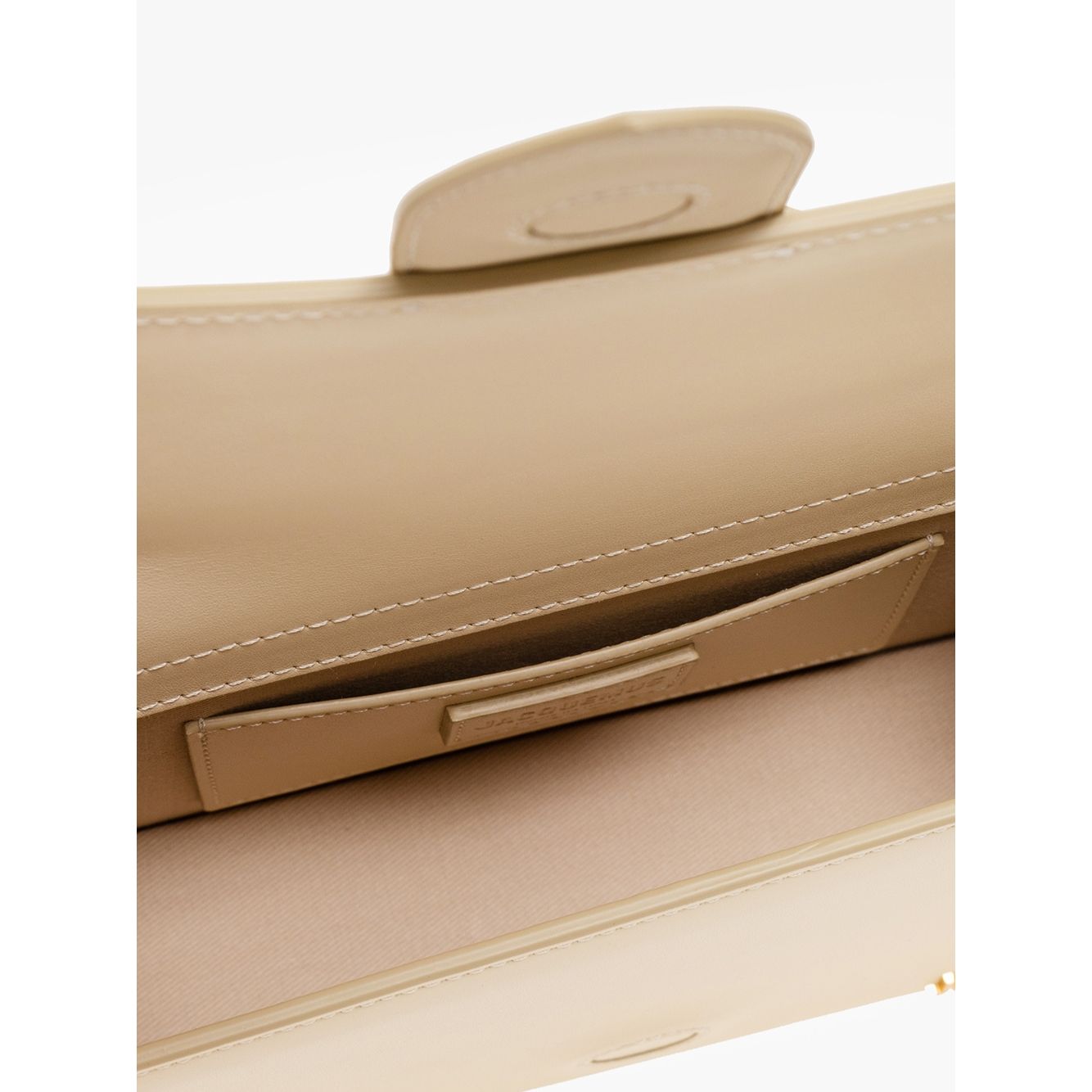 Interior view of Jacquemus Le Grand Bambino Beige Bag showing card pocket and magnetic flap closure with gold logo detail.