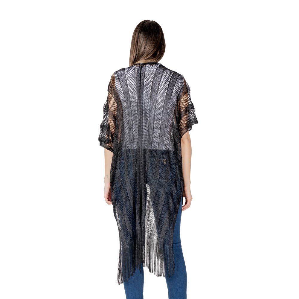 Back view of woman wearing Liu Jo Black Polyester Scarf poncho with fringes, styled elegantly over casual attire.