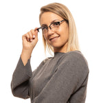 Woman wearing Lozza Black Unisex Glasses Frame smiling, showcasing half-rim trapezium lenses and metal-plastic black frame.