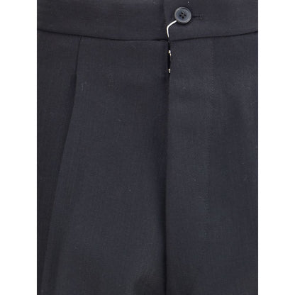 Close-up of Margiela Black Wool Dress Pants showing pleated front and logo hook-and-button closure.
