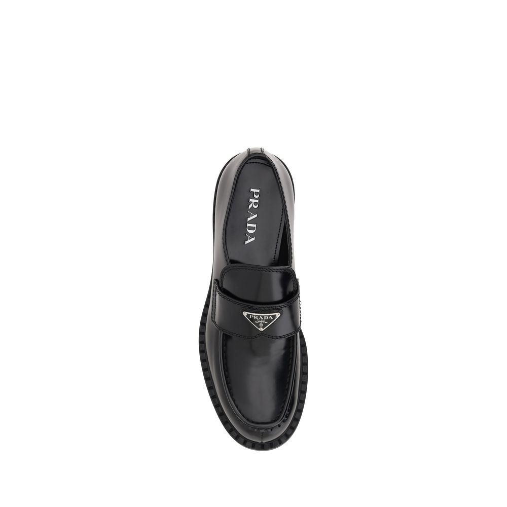 Prada Black Rubber Platform Loafers with enameled triangular logo, featuring a textured platform sole and elongated round toe.