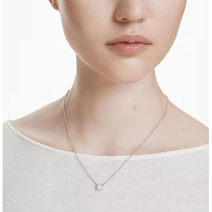 Close-up of woman wearing SWAROVSKI Mod. 5696039 minimalist pendant necklace from Imber Collection, rhodium plated, round-cut stone.