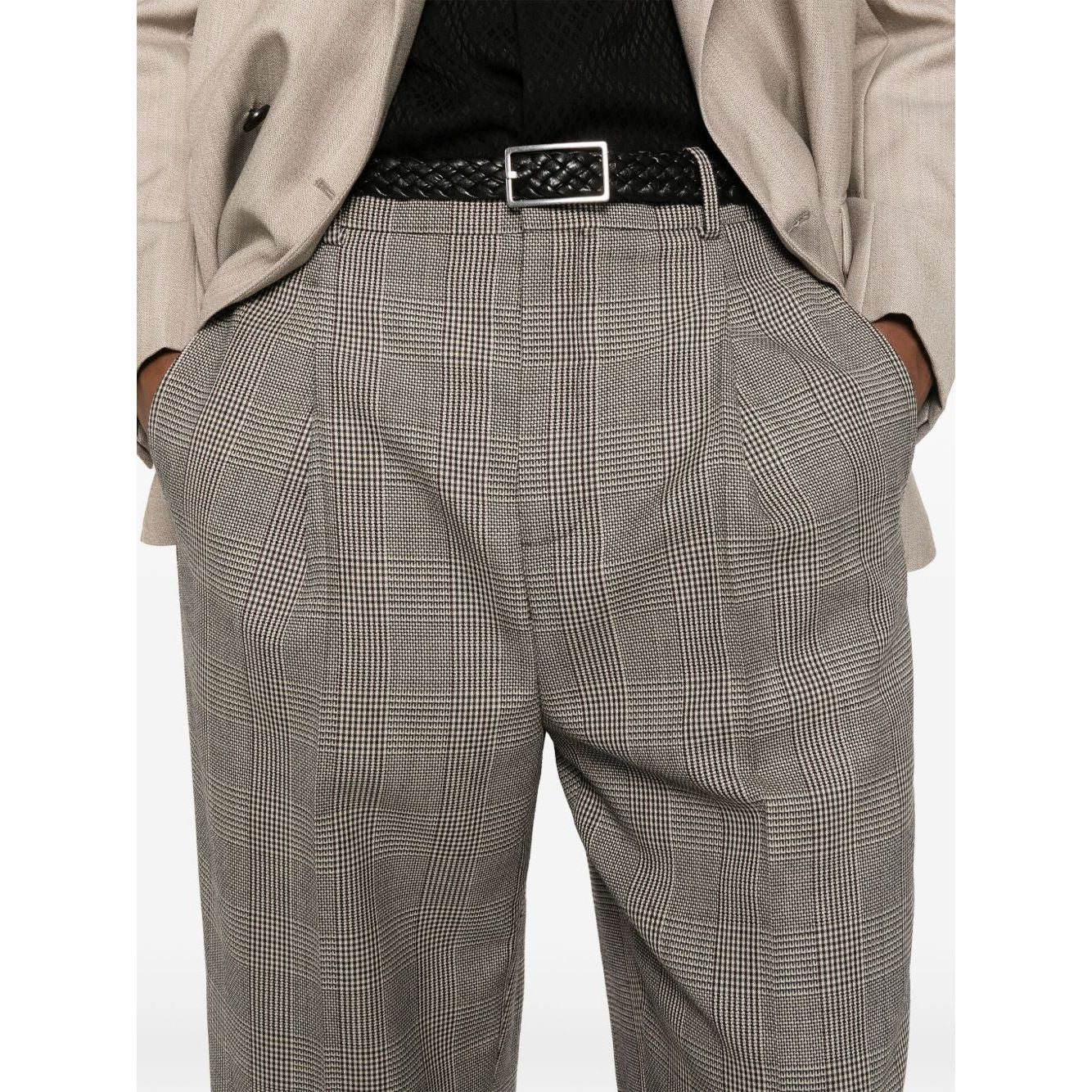 Close-up of person wearing plaid trousers with black belt and beige blazer. Fashionable office attire showcasing classic style.