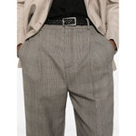 Close-up of person wearing plaid trousers with black belt and beige blazer. Fashionable office attire showcasing classic style.