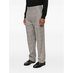 Model wearing Saint Laurent trousers, light brown wool with belt loops, side and rear pockets, and concealed front fastening.