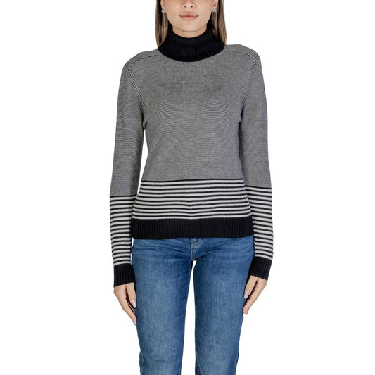 Woman wearing Sandro Ferrone Black And White Viscose Turtleneck sweater with striped pattern.
