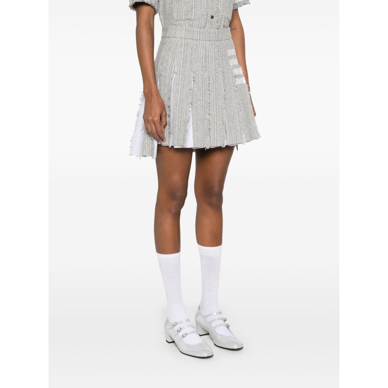 Model wearing Thom Browne Skirts Grey, featuring medium grey color, side button zip, frayed edge, and signature 4-Bar stripe.