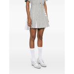 Model wearing Thom Browne Skirts Grey, featuring medium grey color, side button zip, frayed edge, and signature 4-Bar stripe.
