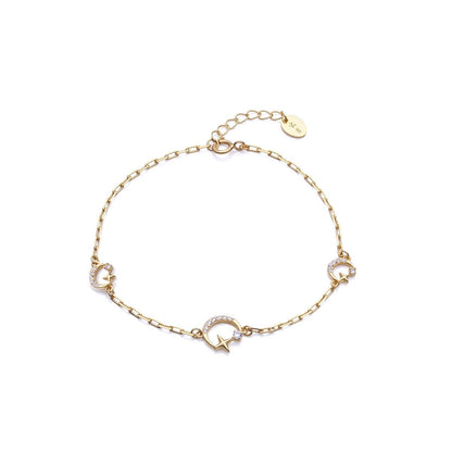Gold bracelet with star and moon charms, featuring elegant design with a delicate chain and clasp for ladies.