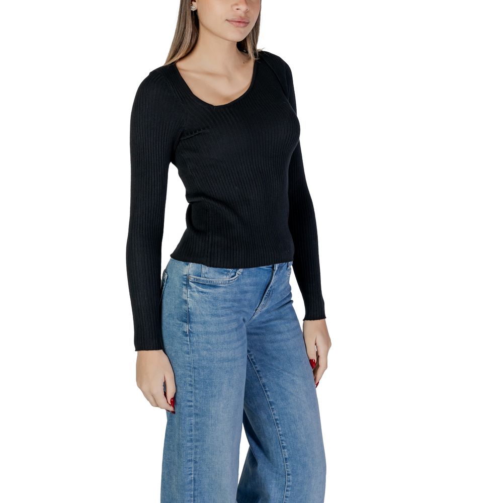 Model wearing Vila Clothes Black Viscose Sweatshirt with ribbed design and asymmetric neckline, paired with blue jeans.
