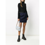 Woman wearing black Wolford Sweaters Black with turtle-neck and long sleeves, paired with a navy skirt and black boots.